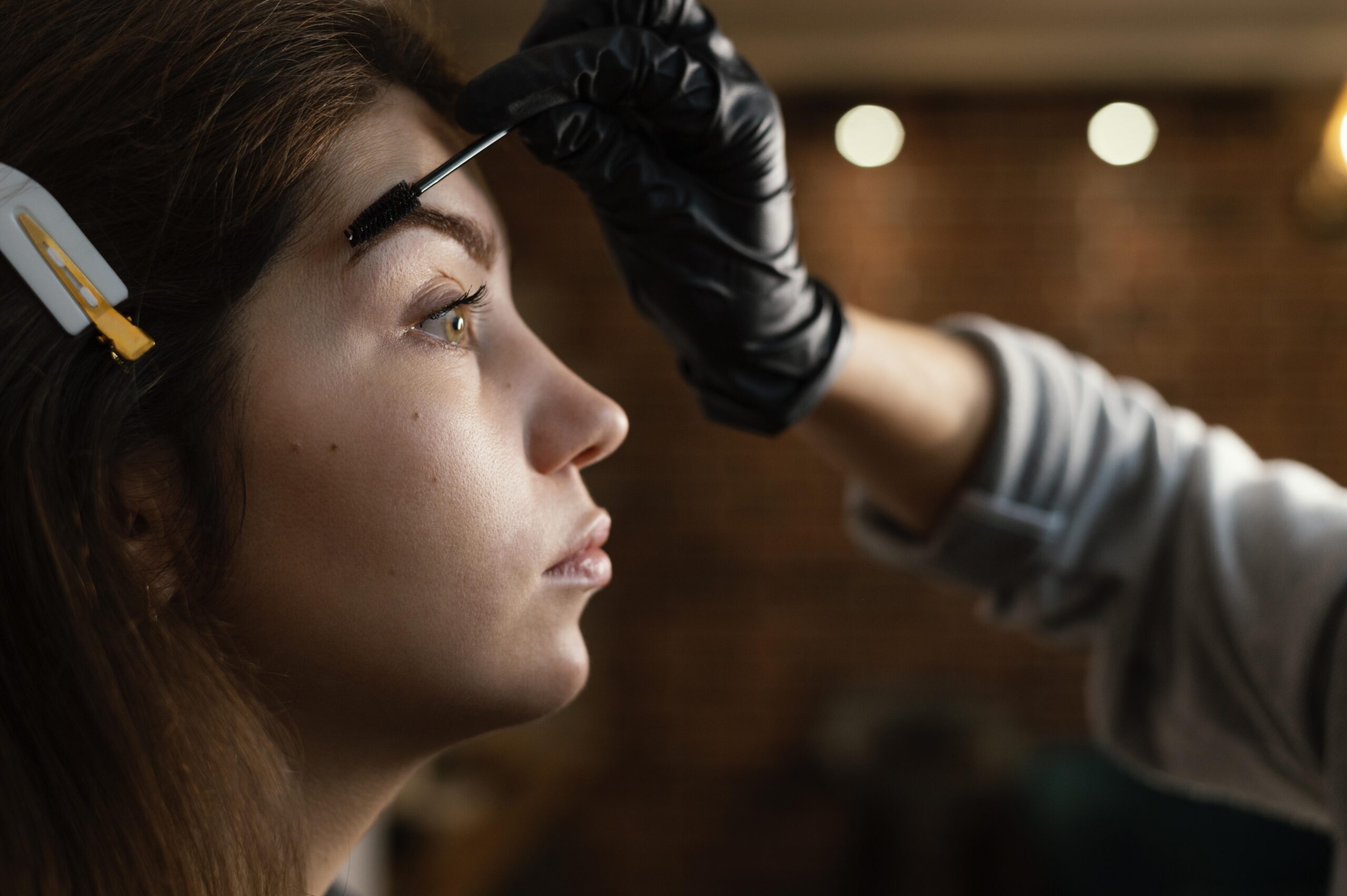 Custom eyebrow shape threading: technician performing precise hair-by-hair shaping treatment