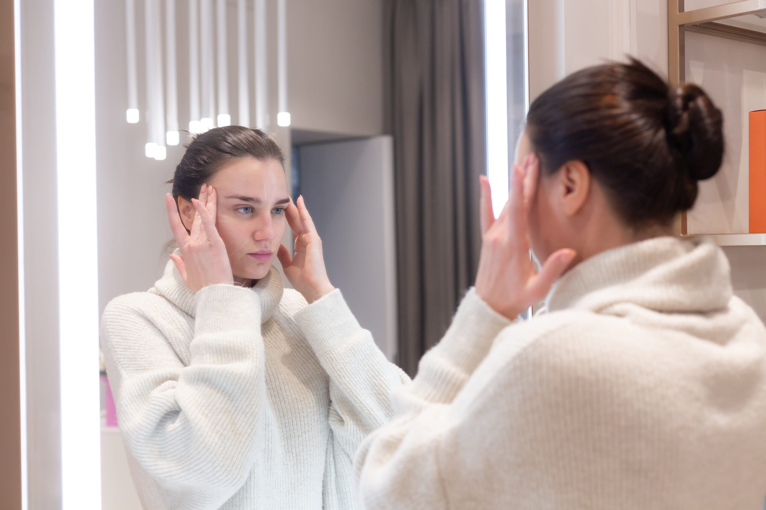 How long does eyebrow threading last: client checking her results in the mirror