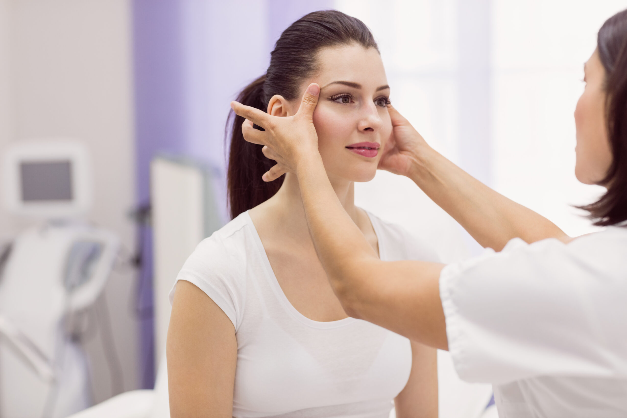 Dermatologist examining a client's skin before laser hair removal near Prospect Heights Brooklyn