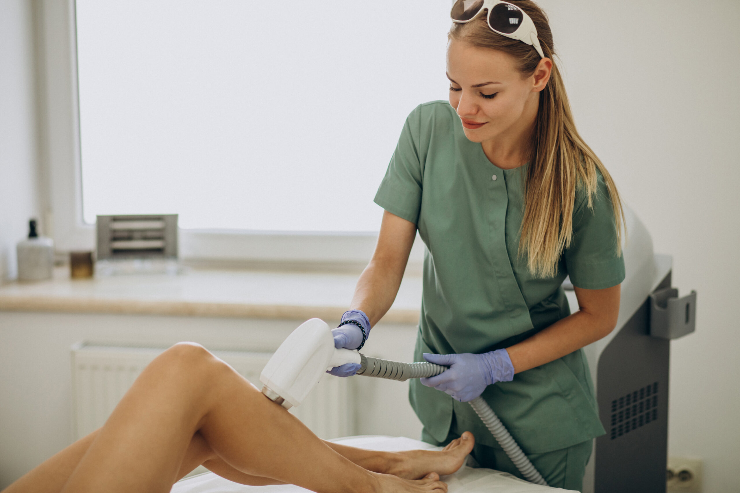 Technician performing laser hair removal treatment on a client's leg in a Brooklyn clinic