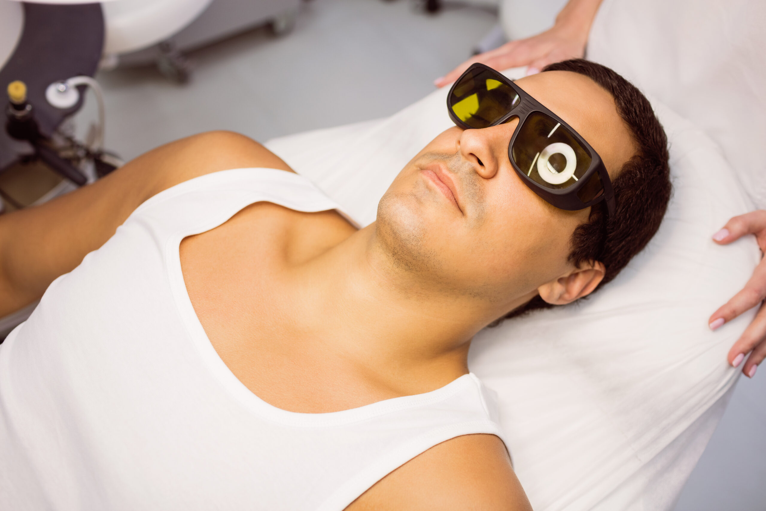 Male patient wearing laser protective glasses before a sensitive-skin treatment session at a Brooklyn clinic