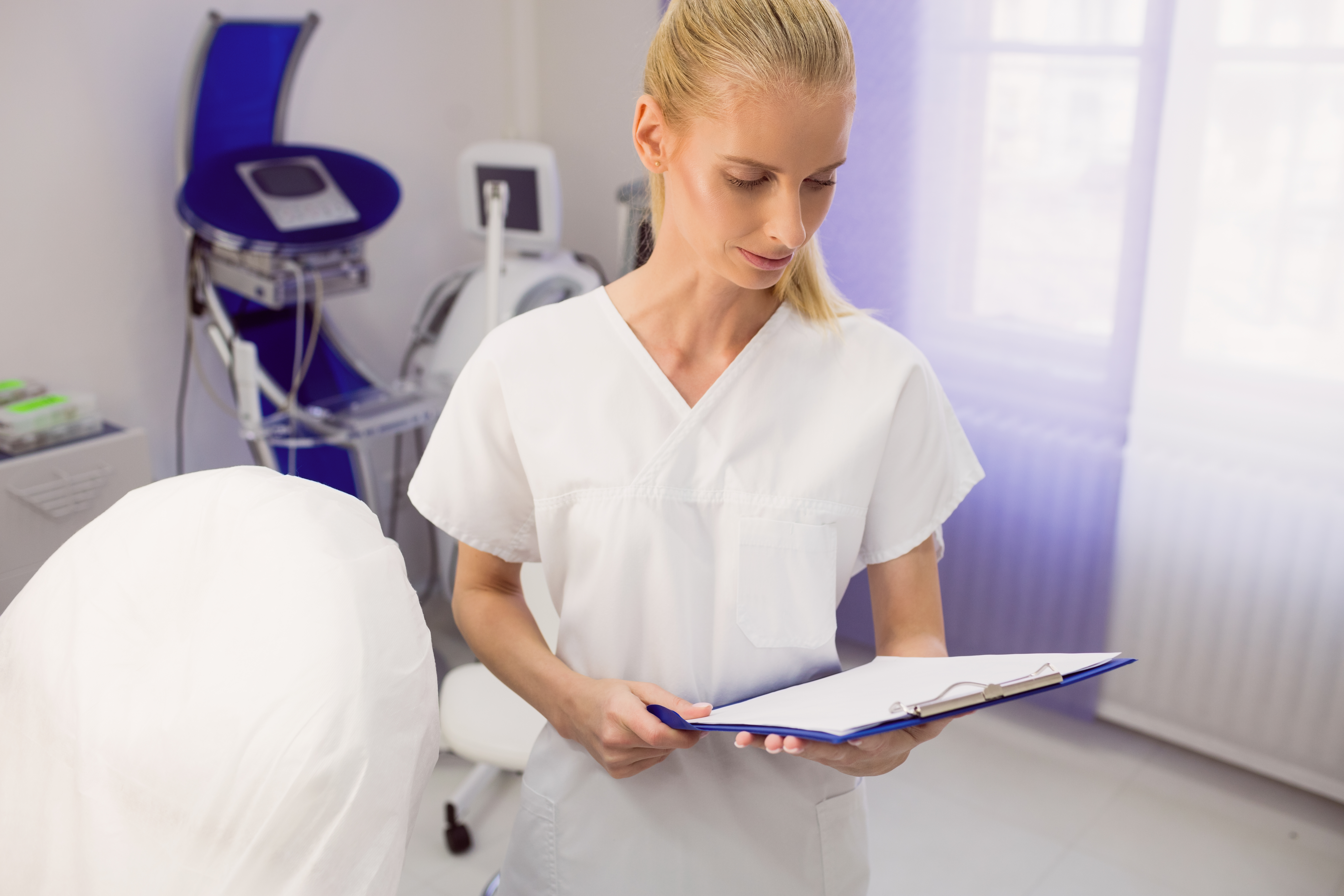Technician reviewing an appointment calendar at a Brooklyn laser hair removal clinic