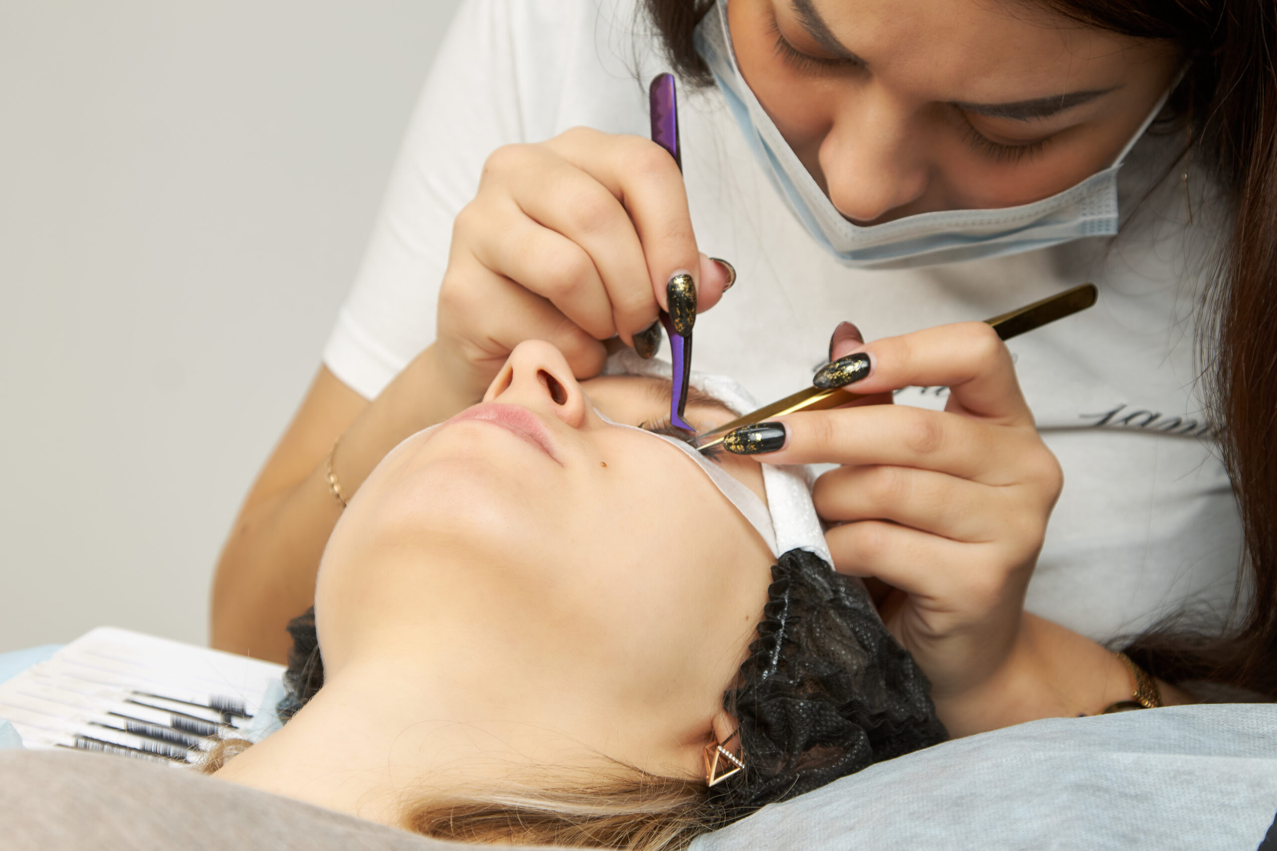Difference between a lash fill and a full new set, close-up of eyelash extension application