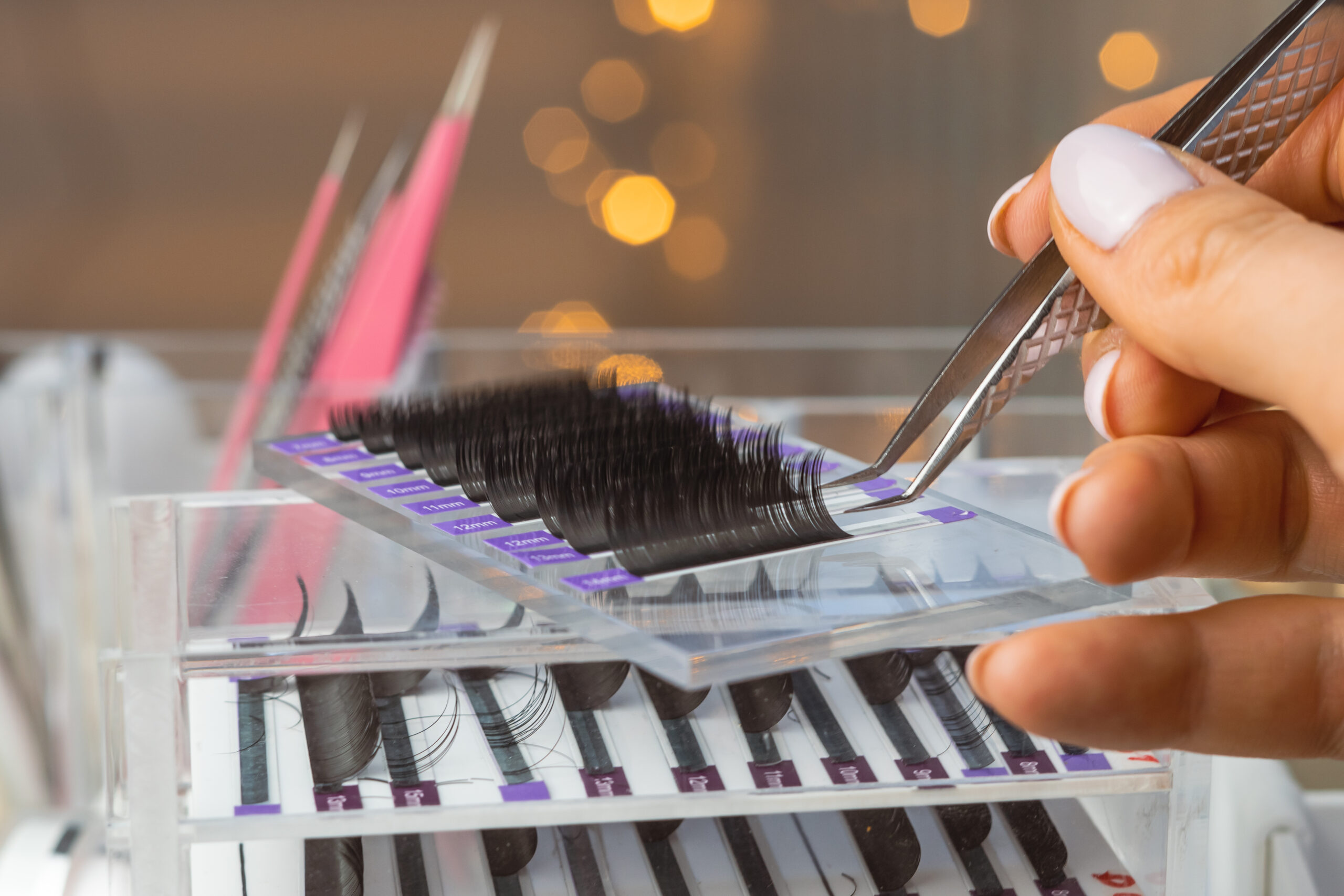 Difference between a lash fill and a full new set, close-up of lash extension tools and supplies