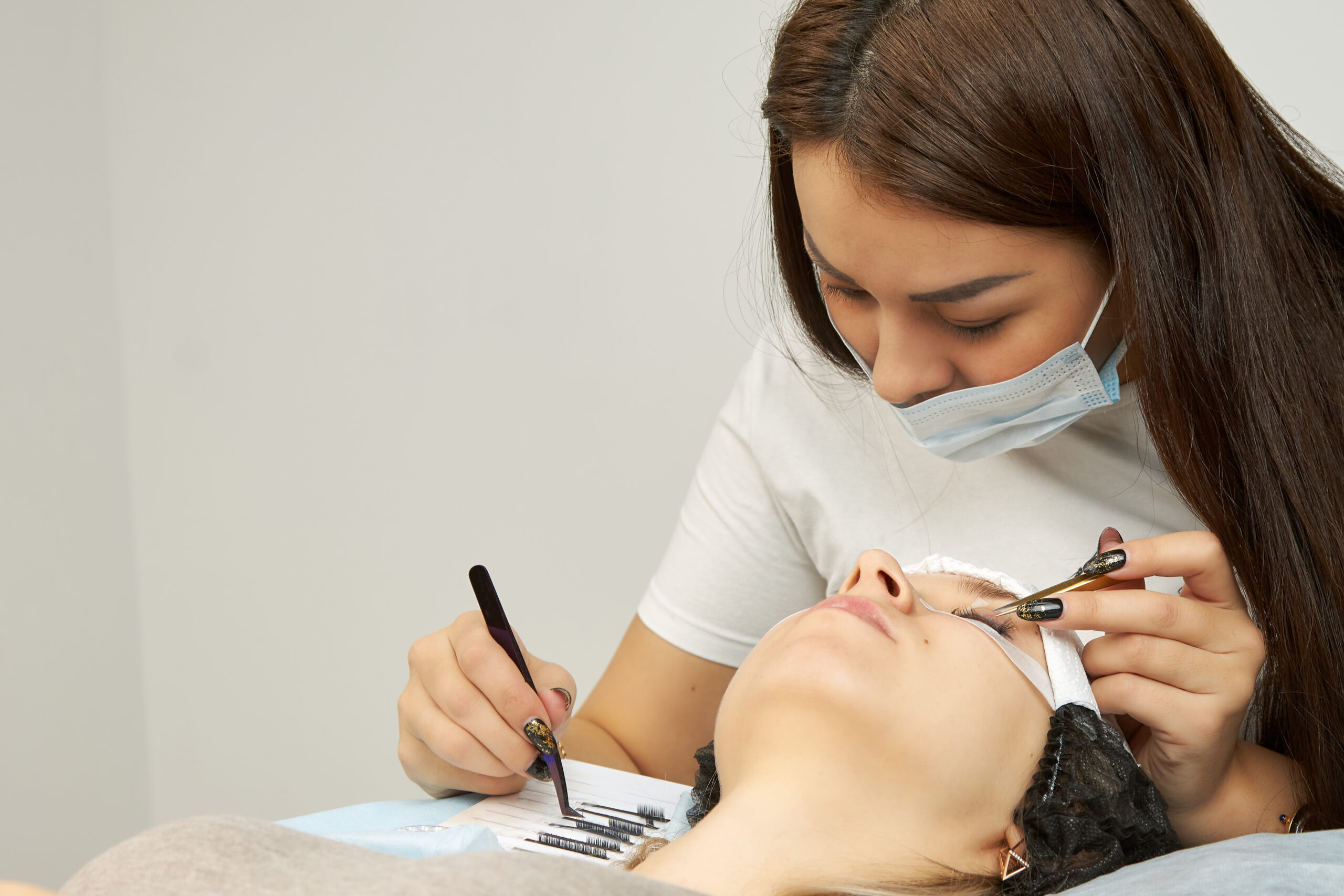 Preparing for your first lash extension appointment, technician applying extensions with precision